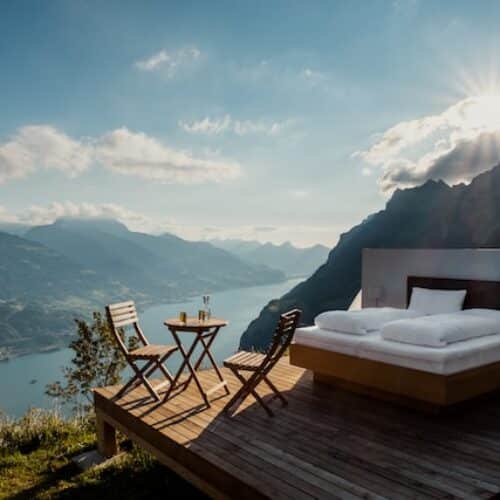 Bed and chairs at a mountain lake
