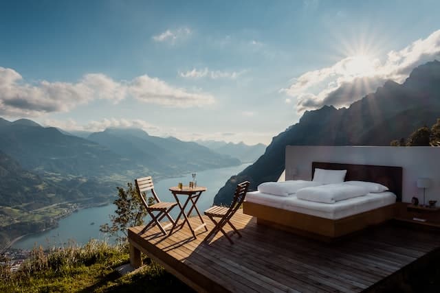 Bed and chairs at a mountain lake